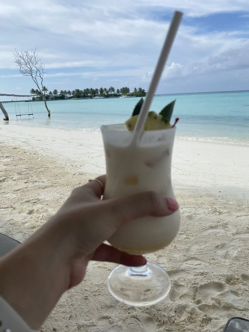 Cocktail in de hand aan het strand van Sun Island, onderdeel van de all-inclusive