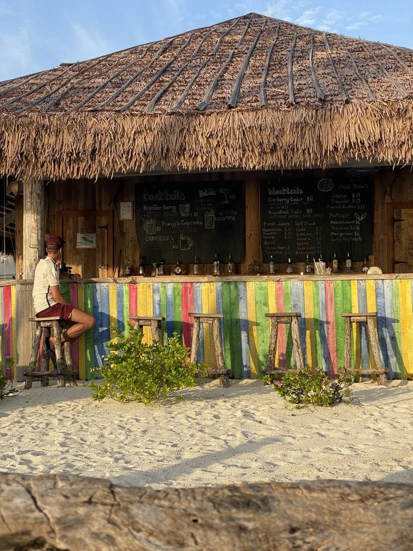 Strandbar met rieten dak en kleurrijke hangmatten op Sun Island
