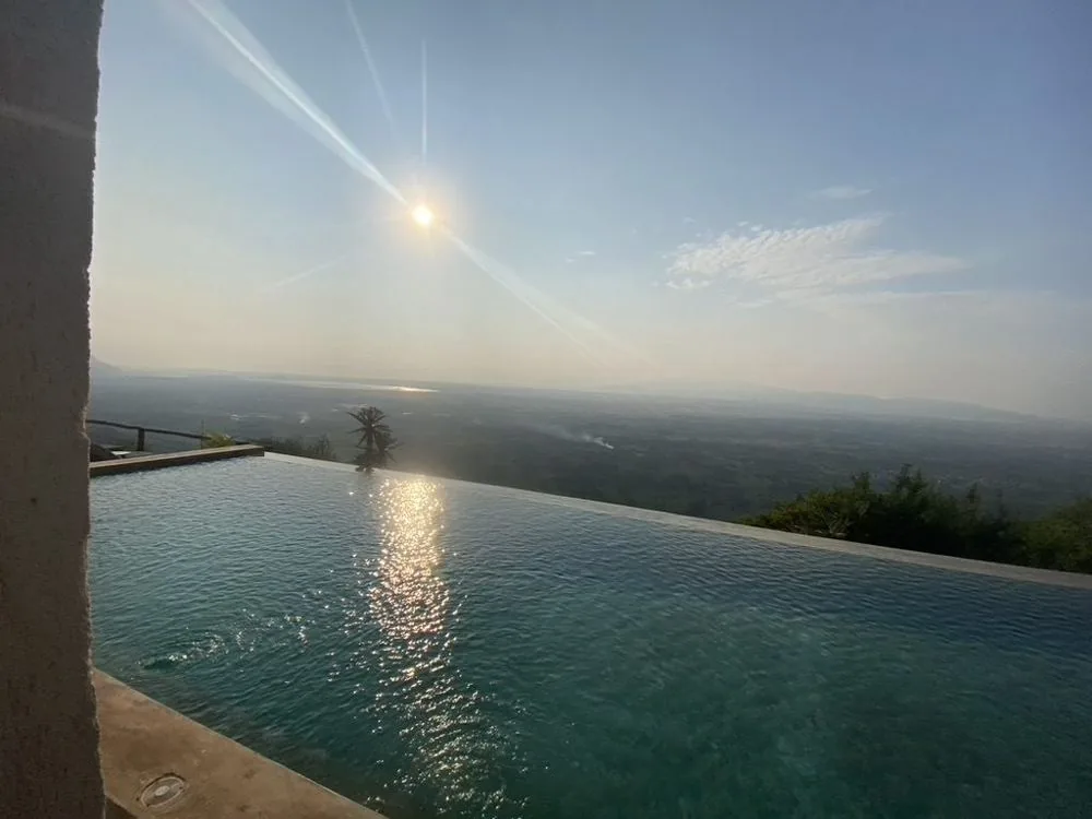 Infinity pool van de lodge met uitzicht over de vlaktes bij Lake Manyara bij zonsondergang