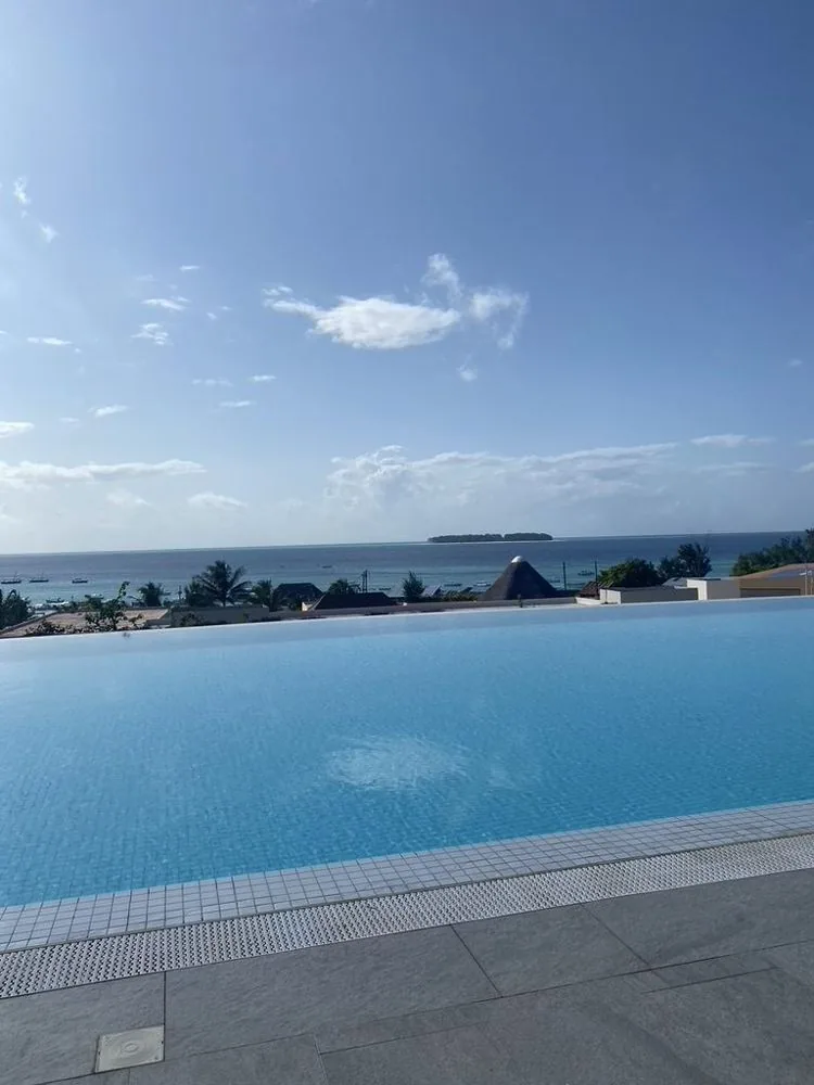 Zwembad met uitzicht over de oceaan en een eilandje op Zanzibar